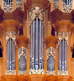 Wood sculpture of multiple faces in pipe shade carvings for the Fritts pipe organ at Pacific Lutheran University, Tacoma WA